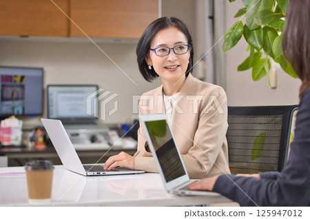 Middle-aged woman having a meeting in the office Middle-aged woman having a meeting in the office 125947012
