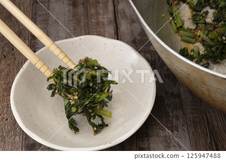 使用蘿蔔葉製作拌飯料的過程。炒蘿蔔葉。葉蘿蔔拌飯。炒蘿蔔葉。 125947488