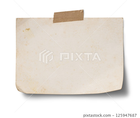 A postcard-sized piece of old paper taped to the wall with brown tape 125947687