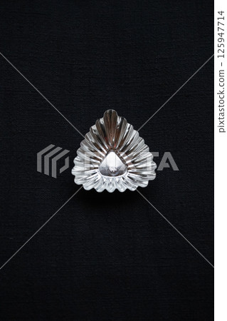 Vertical composition of a triangular tray on a hand-spun indigo-dyed cloth 125947714