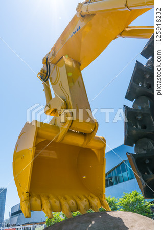 北陸新幹線小松站前晴朗的藍天和展示的大型重型機械 |液壓挖掘機 |反鏟挖土機 |石川縣小松市 125948232