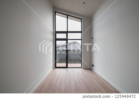 A Minimalist Modern Room that Features Large Windows Allowing in Abundant Natural Light 125948472