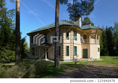 An Elegant and Modern House Beautifully Surrounded by Serene Nature and Lush Greenery 125948476