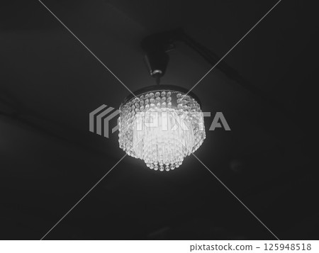 An Elegant Chandelier Gracefully Illuminating a Dark Space with Sophisticated Ambiance An Elegant Chandelier Gracefully Illuminating a Dark Space with Sophisticated Ambiance 125948518
