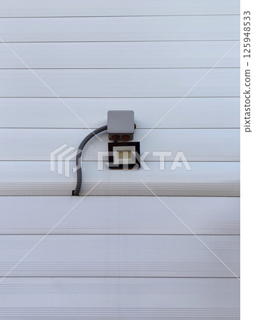wall-mounted light fixture showcases minimalistic design on white panel background in modern setting wall-mounted light fixture showcases minimalistic design on white panel background in modern setting 125948533