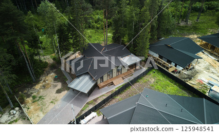 A Stunning Aerial View of Contemporary Modern Homes Nestled in a Lush Tree Surrounding Area 125948541