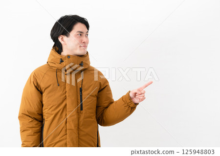 Young man wearing a down coat 125948803