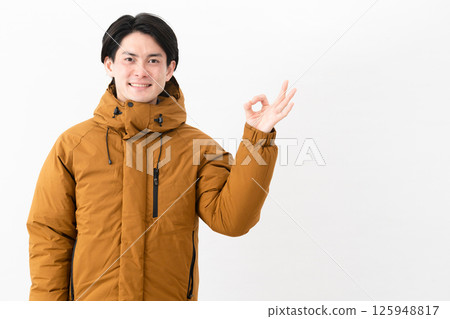 Young man wearing a down coat Young man wearing a down coat 125948817