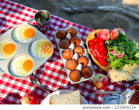 Sunny breakfast spread with eggs and fresh produce on checkered tablecloth Sunny breakfast spread with eggs and fresh produce on checkered tablecloth 125950114