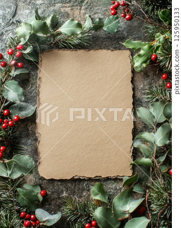 Blank textured craft paper with festive greenery and red berries for holiday invitations or craft projects 125950133