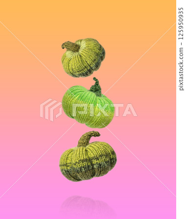 Flying knitted green pumpkins orange and pink gradient background. Concept of autumn, Halloween, Thanksgiving. Diy Home Decor. Knitting toys and decorations for home Flying knitted green pumpkins orange and pink gradient background. Concept of autumn, Halloween, Thanksgiving. Diy Home Decor. Knitting toys and decorations for home 125950935