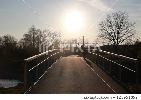 A bridge over a river with a person walking across it A bridge over a river with a person walking across it 125951852