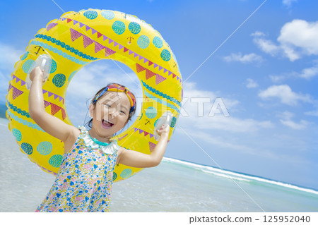 一個女孩在夏日的海裡玩游泳圈 一個女孩在夏日的海裡玩游泳圈 125952040