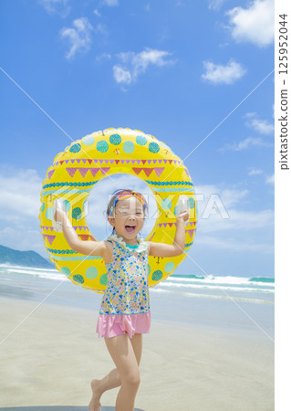 一個女孩在夏日的海裡玩游泳圈 125952044