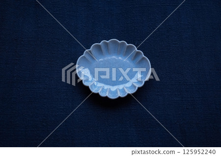 放在手工紡製靛藍染布上的小盤子 125952240