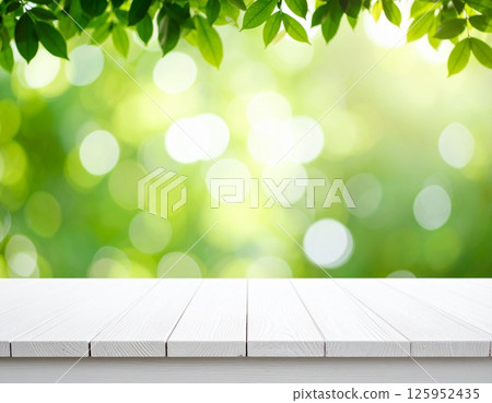 白色木質甲板上綠樹成蔭，陽光透過樹木照射進來 125952435