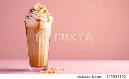 Creamy caramel milkshake topped with whipped cream and caramel drizzle on pink background 125953192