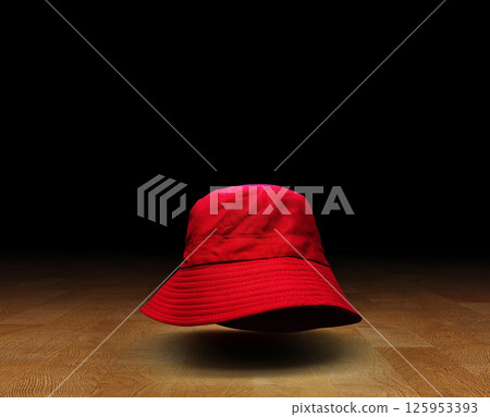 Red bucket hat on wooden floor, black background. Red bucket hat on wooden floor, black background. 125953393