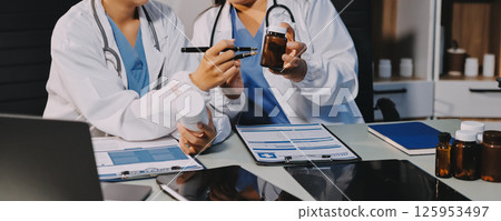 Male and female doctors are having a meeting in a hospital room. 125953497