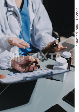 Male and female doctors are having a meeting in a hospital room. 125953502