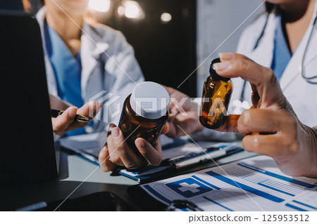 Male and female doctors are having a meeting in a hospital room. 125953512