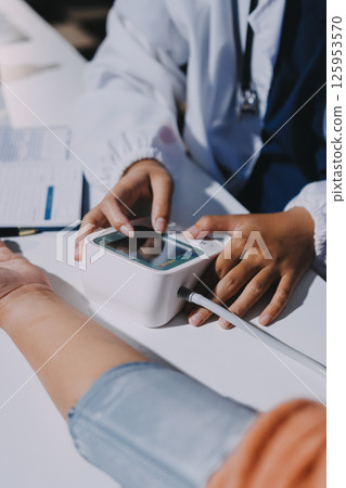 Nurse measuring blood pressure of elderly woman at table, closeup. Assisting senior generation 125953570