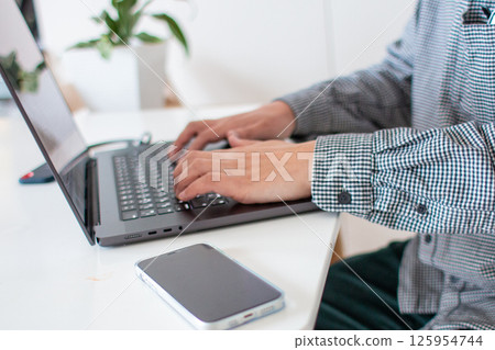 Desk work of a man working from home Desk work of a man working from home 125954744