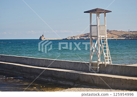 Wooden tower for observation of the beach on the seashore Wooden tower for observation of the beach on the seashore 125954996