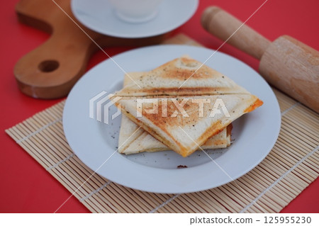 a neatly plated pair of toasted sandwich triangles on a white plate a neatly plated pair of toasted sandwich triangles on a white plate 125955230