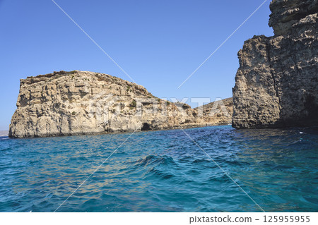 Rocky cliffs at crystal lagoon on European Comino island in Malta Rocky cliffs at crystal lagoon on European Comino island in Malta 125955955