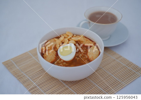 a bowl of spicy Indonesian-style instant noodles served with a boiled egg a bowl of spicy Indonesian-style instant noodles served with a boiled egg 125956043