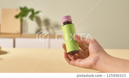 The collagen bottle is made of glass to ensure the quality of the essence inside and to preserve it for a long time. The outside of the bottle has a smooth green shell and a purple plastic cap.  125956323