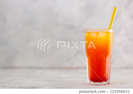 Dirty Soda with Yellow Straw in Tall Glass on Gray Background, Copy Space 125956631