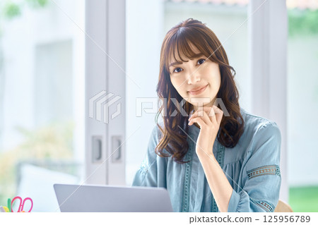 Young woman operating a personal computer at home Young woman operating a personal computer at home 125956789