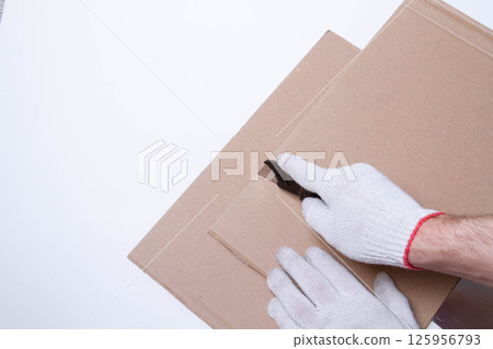Packing the goods in a cardboard box and stretch film. Tools for packing parcels at the post office. 125956793