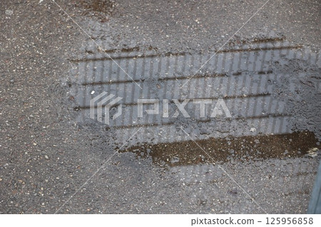 A puddle of water on a sidewalk 125956858