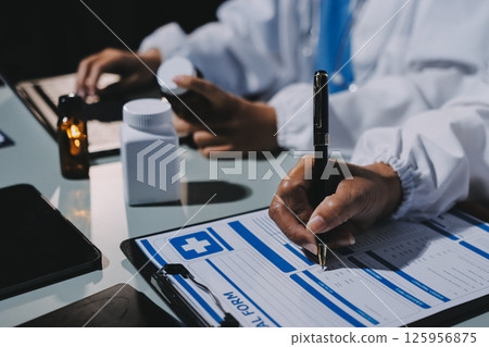 Male and female doctors are having a meeting in a hospital room. Male and female doctors are having a meeting in a hospital room. 125956875