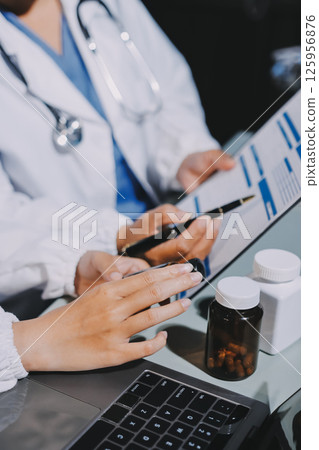 Male and female doctors are having a meeting in a hospital room. Male and female doctors are having a meeting in a hospital room. 125956876