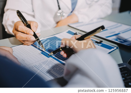 Male and female doctors are having a meeting in a hospital room. 125956887