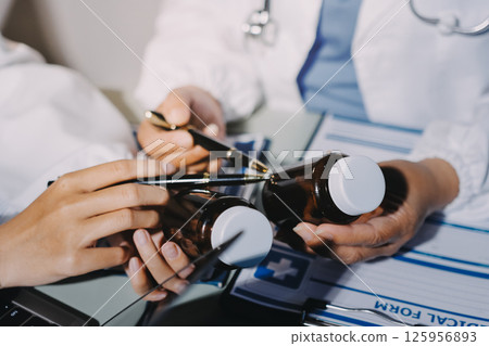 Male and female doctors are having a meeting in a hospital room. Male and female doctors are having a meeting in a hospital room. 125956893
