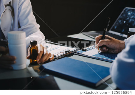 Male and female doctors are having a meeting in a hospital room. Male and female doctors are having a meeting in a hospital room. 125956894