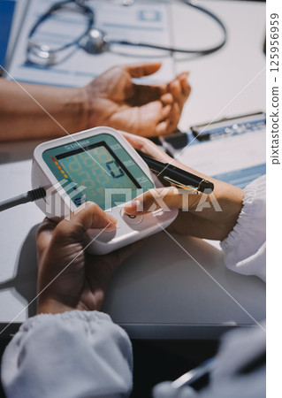 Nurse measuring blood pressure of elderly woman at table, closeup. Assisting senior generation 125956959