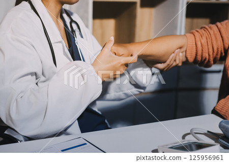 Orthopedist examining patient in hospital 125956961