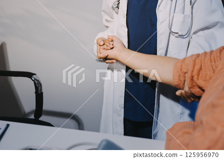 Orthopedist examining patient in hospital 125956970