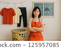 A woman having trouble doing laundry in the rain 125957085
