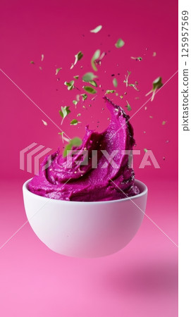 Purple dairy product splashing dynamically, garnished with fresh herbs against vivid pink background, highlighting culinary vibrancy and texture for marketing purposes 125957569