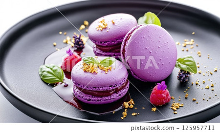 Delicious purple macaroons served on a black plate with fresh berries and mint leaves, showcasing a delightful French pastry experience, dessert concept 125957711