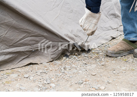 [Auto camping on the Nakatsugawa riverbed, removing the pegs from the tent skirt and preparing to withdraw] 125958017