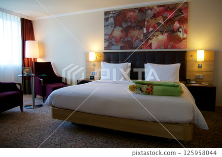 Mainz, Germany, July 8, 2017: Hotel Room with Double Bed and Red Lounge Chair Mainz, Germany, July 8, 2017: Hotel Room with Double Bed and Red Lounge Chair 125958044