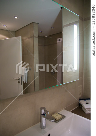 Mainz, Germany, July 8, 2017: Hotel Bathroom with Sink, Mirror, and Bright Tiles Mainz, Germany, July 8, 2017: Hotel Bathroom with Sink, Mirror, and Bright Tiles 125958046